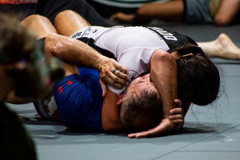 An adult securing back control during a roll