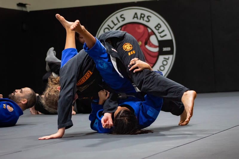 An athlete inverting in guard under the logo backdrop