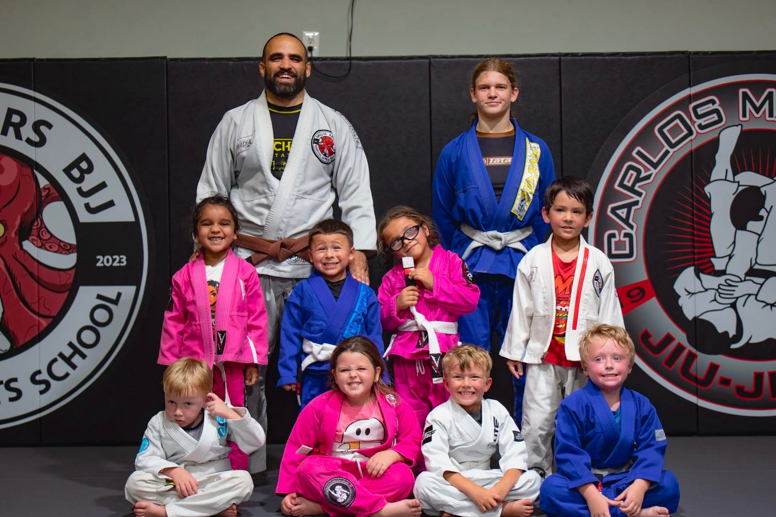 The full Mollis Ars BJJ kids class gathered for a group photo on the mat