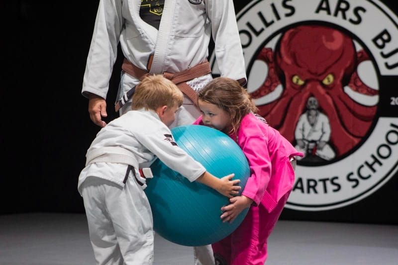 Two kids carrying a large exercise ball during a game