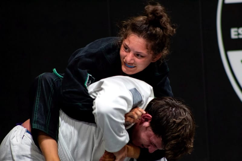 A young woman working from the top in a competition match